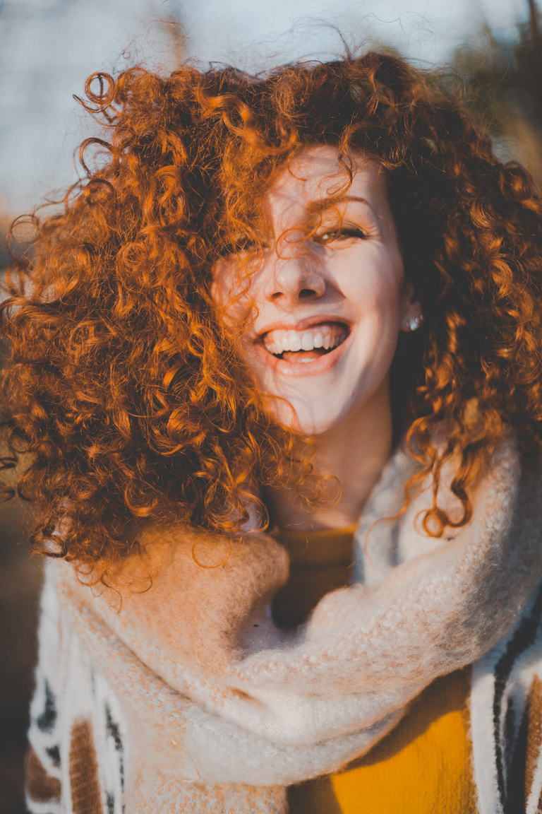 Woman Wearing Gray Knitted Scarf While Smiling